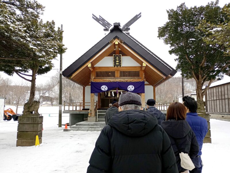 初詣に訪れた参拝者と石山神社の社殿