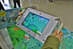 札幌市下水道科学館の豊平川とその周辺に生息する生き物のイラストが表示されるタブレット
