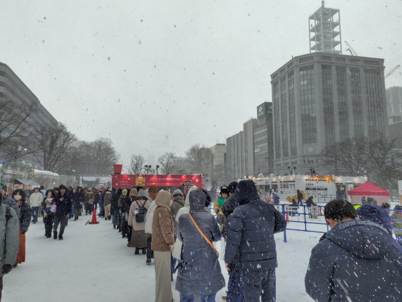 2025年さっぽろ雪まつりの3丁目会場で辛ラーメン無料配布を待つ人の列