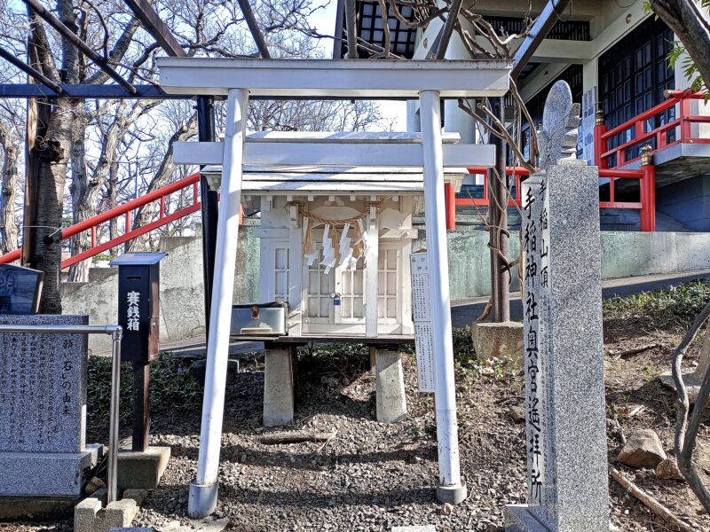 白い鳥居と祠が印象的な手稲神社境内の藤白龍神社